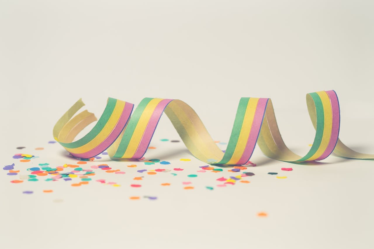Bright pastel paper streamer with scattered confetti, perfect for celebration themes.